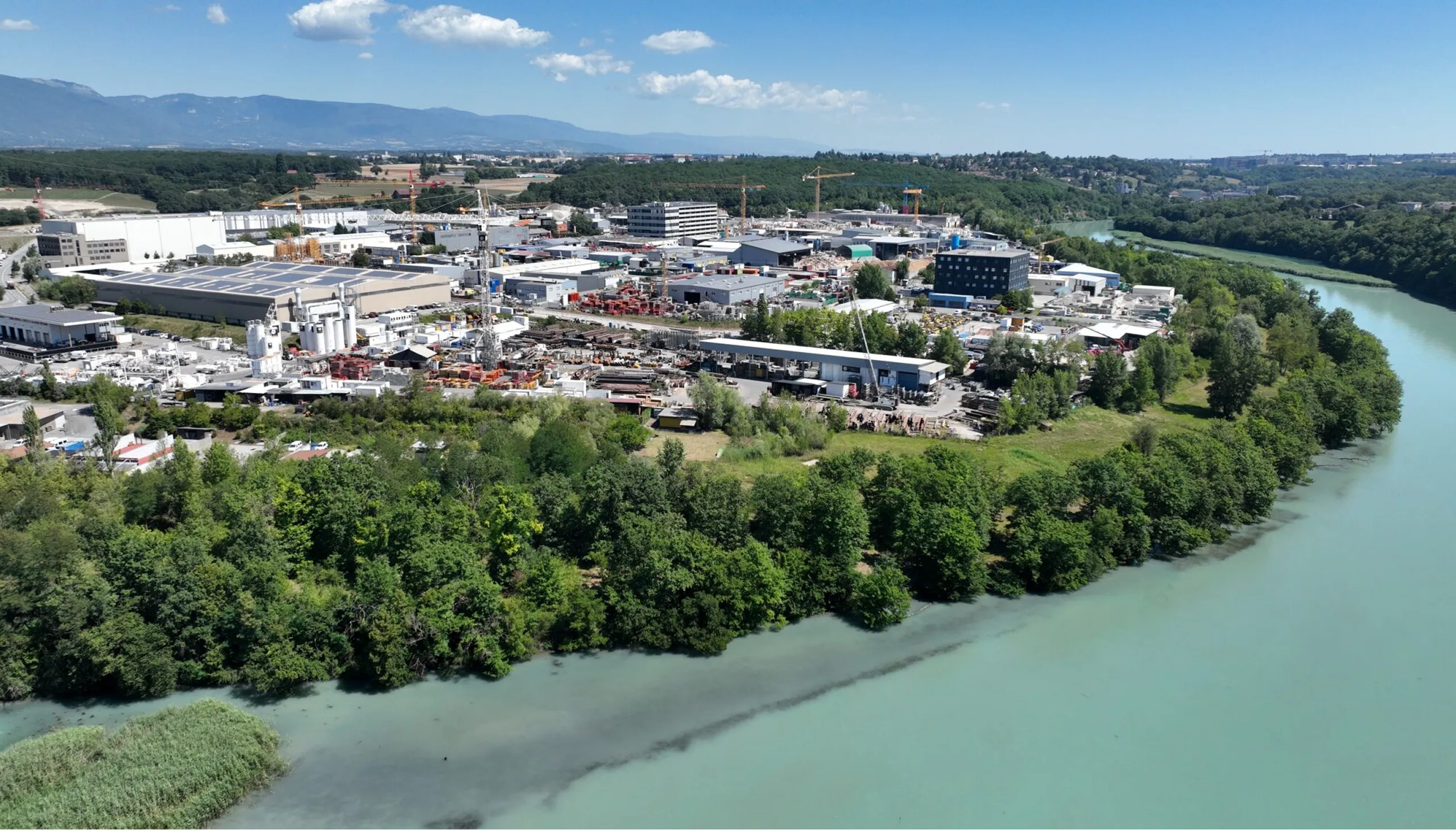 Vue aérienne de la zone ZIBAY, en bordure du Rhône, Jura à l'horizon
