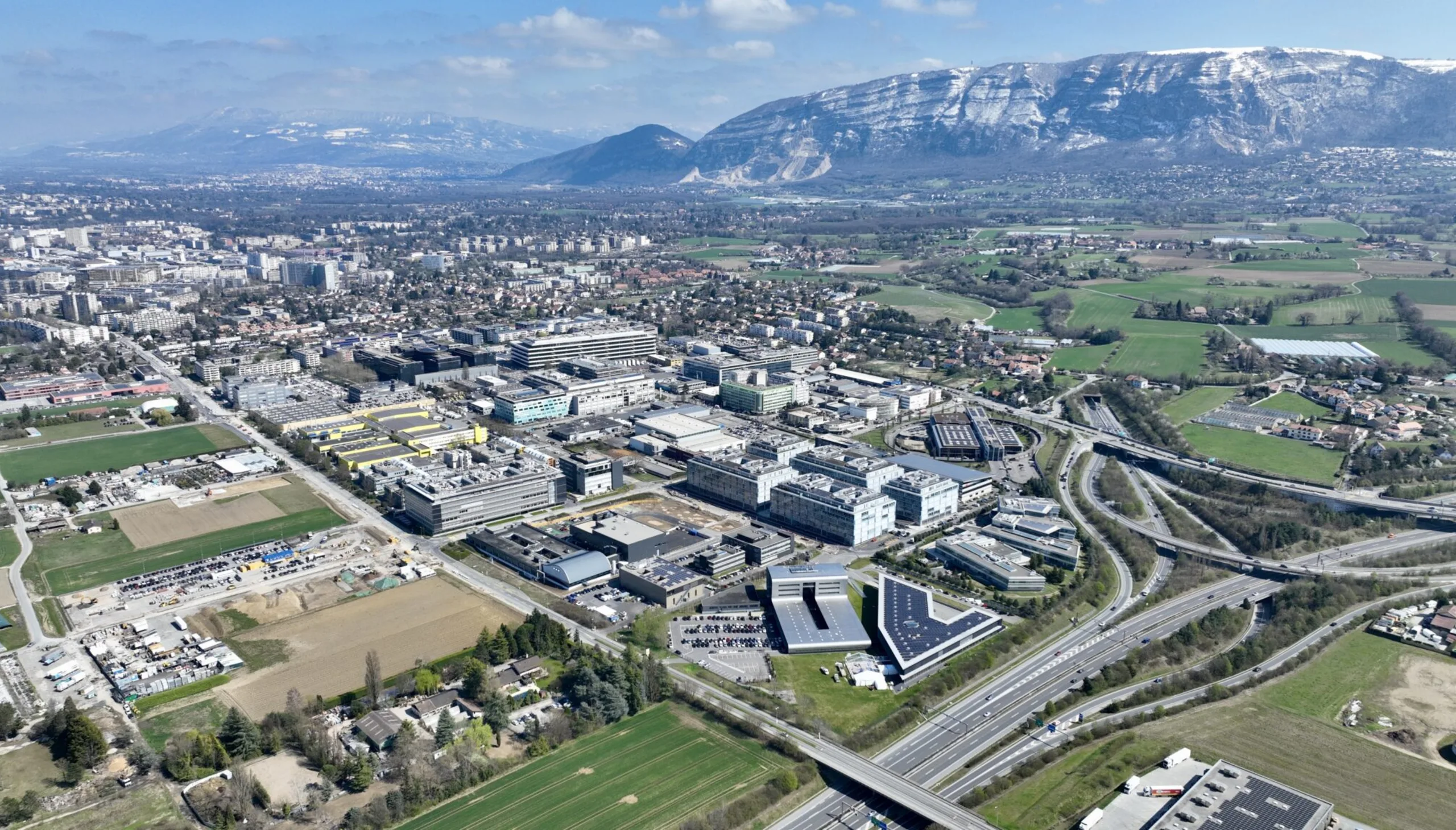 Vue aérienne de la zone ZIPLO à Plan-les-Ouates, tissu d'activités le long de l'autoroute