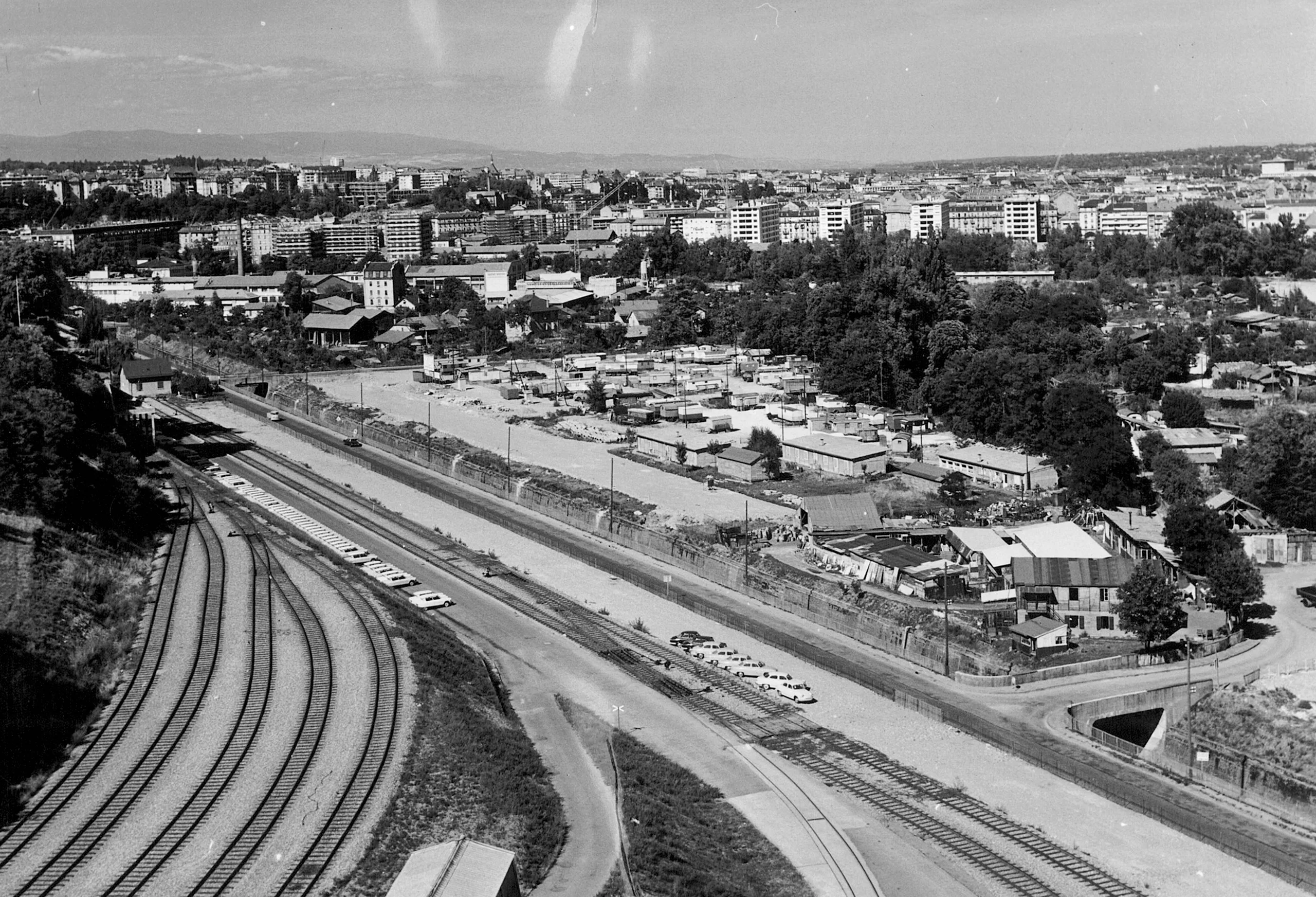 Vue aérienne historique en noir et blanc du secteur PAV, avec voies ferrées et halles industrielles
