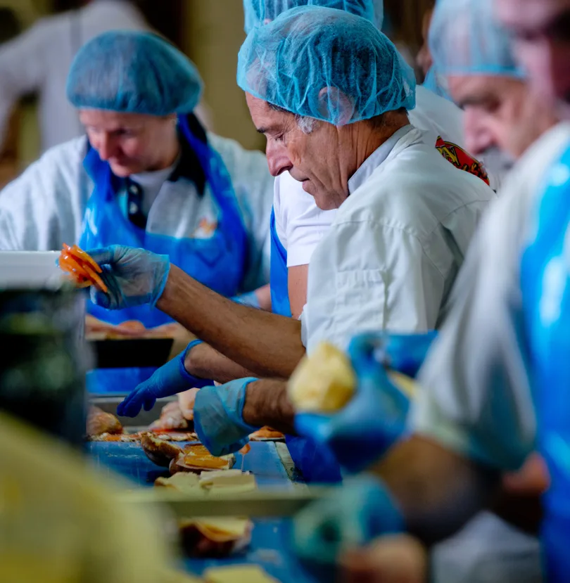 Ligne de production alimentaire : ouvriers en charlotte préparant des aliments