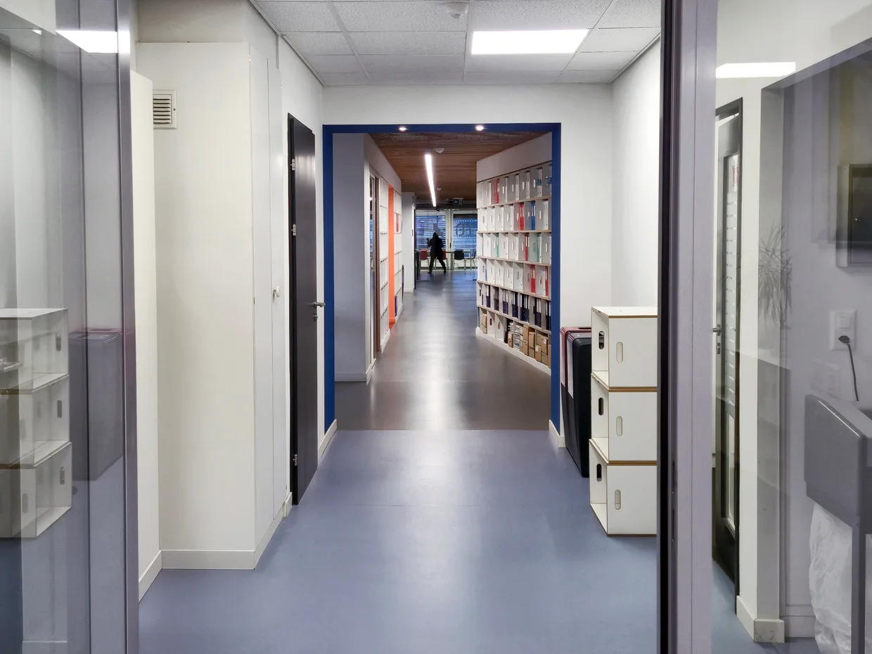 Couloir des bureaux de la FTI, avec portes, rangements et archives
