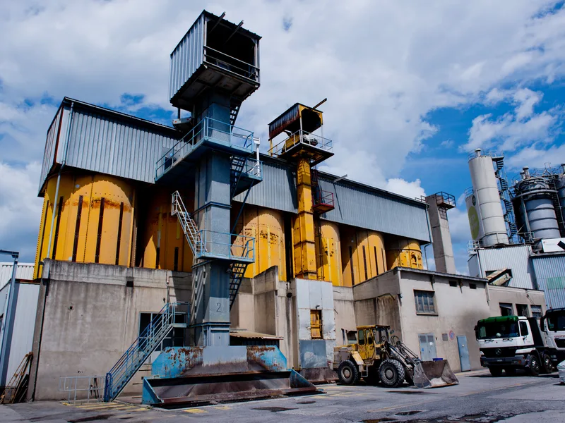 Installation industrielle avec silos et chargeuse sur pneus, en zone d'activités
